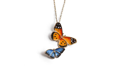 Butterfly-shaped pendant on a chain against a white background